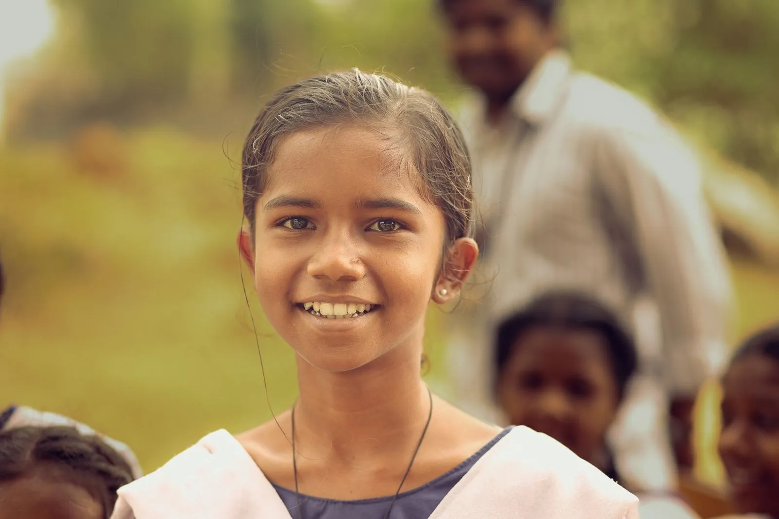 A smiling schoolgirl in a village