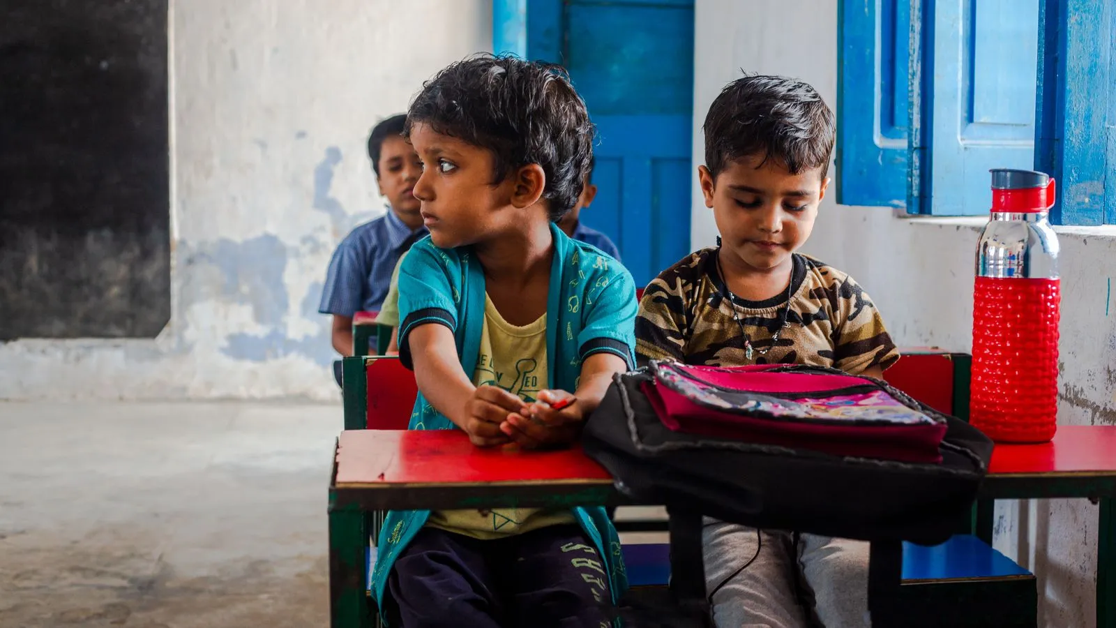 Two children at their desks in a classroom