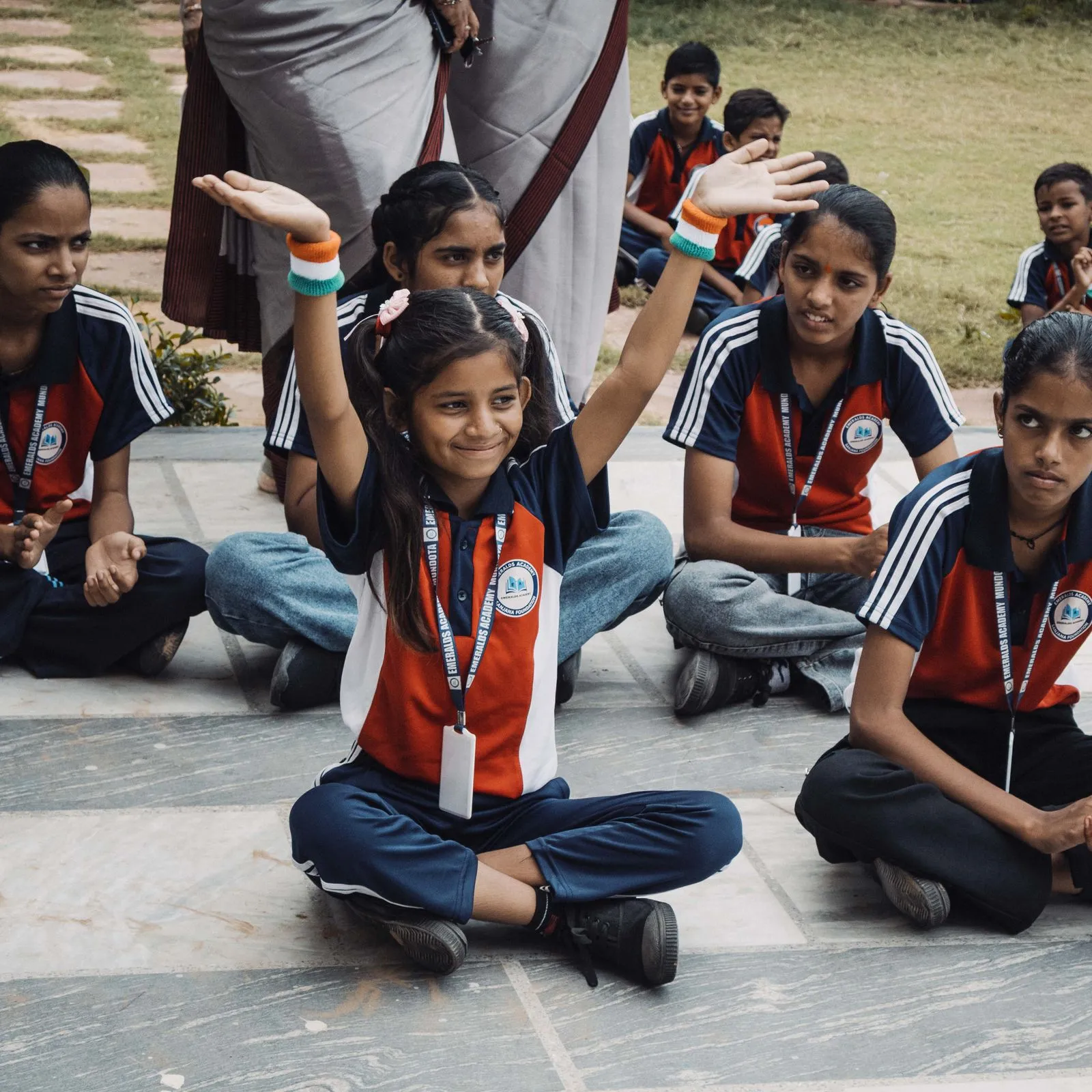 A schoolgirl raising her hands among classmates
