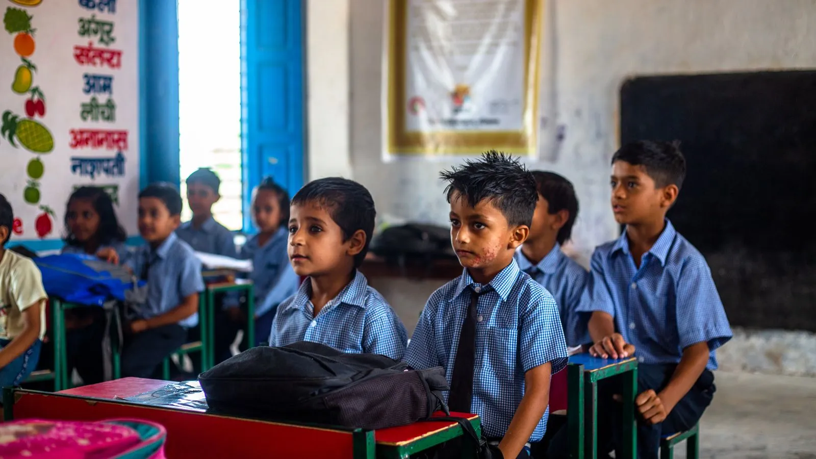 Schoolchildren in uniform listening in a classroom in India