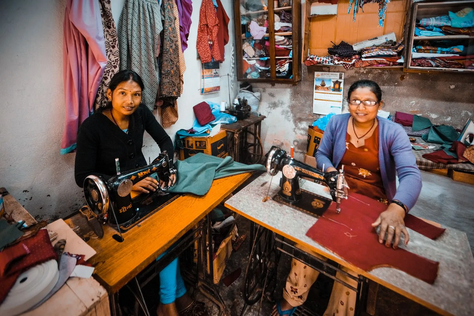 Two dressmakers at their sewing machines in a workshop