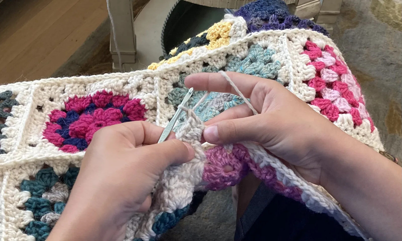 Hands joining crochet squares