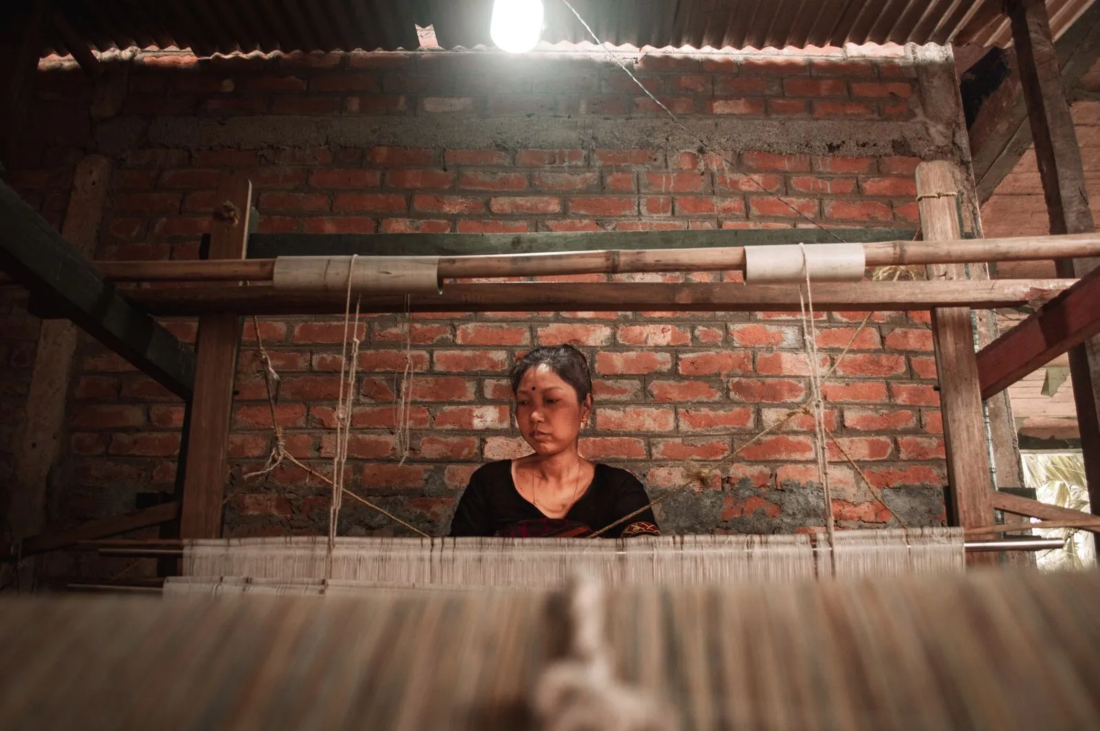A woman weaving at a handloom